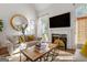 Cozy living room with fireplace, large TV, and natural light from the windows at 4729 Woodland Brook Se Ct, Atlanta, GA 30339