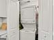 Laundry closet with stacked washer and dryer and built-in storage shelves for supplies at 830 Bonnie Glen Se Dr, Marietta, GA 30067