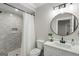 Contemporary bathroom with sleek design elements, including a tiled shower and a round mirror at 2101 Thomas Rd, Canton, GA 30115