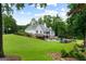 Stunning rear exterior featuring a large home, lush lawn, and a beautiful in-ground pool at 2101 Thomas Rd, Canton, GA 30115