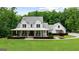 Beautiful white farmhouse with a covered front porch, rocking chairs, and manicured landscaping at 2101 Thomas Rd, Canton, GA 30115