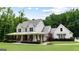 Elegant farmhouse with a large porch and picturesque landscaping, nestled in a lush, green setting at 2101 Thomas Rd, Canton, GA 30115