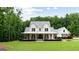 Inviting white farmhouse featuring a spacious covered porch and professionally landscaped front yard at 2101 Thomas Rd, Canton, GA 30115