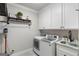 Well-equipped laundry room with modern appliances, storage cabinets, and convenient sink at 2101 Thomas Rd, Canton, GA 30115
