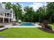 Backyard boasts a luxurious pool, lounge chairs, and outdoor seating for relaxation and entertainment at 2101 Thomas Rd, Canton, GA 30115