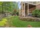 Landscaped backyard with stone retaining wall, mature trees, and walkway at 3088 Hidden Falls Dr, Buford, GA 30519