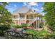 View of backyard with firepit, landscaped lawn, mature trees, and upper level deck at 3088 Hidden Falls Dr, Buford, GA 30519