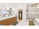 Bathroom featuring a double vanity, arched mirrors, glass shower, soaking tub and entry to closet at 3088 Hidden Falls Dr, Buford, GA 30519