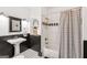 Well-lit bathroom featuring black and white tiles, pedestal sink, and a shower with a striped curtain at 3088 Hidden Falls Dr, Buford, GA 30519