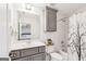 Well-lit bathroom with gray vanity, shower with decorative curtain, and view into the bedroom at 3088 Hidden Falls Dr, Buford, GA 30519