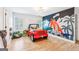Fun bedroom features colorful mural, hardwood floors, and plenty of play space at 3088 Hidden Falls Dr, Buford, GA 30519