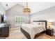 Vaulted ceiling bedroom featuring stylish chandelier, natural light, and neutral color palette at 3088 Hidden Falls Dr, Buford, GA 30519