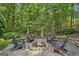 Secluded backyard fire pit area with stone surround and Adirondack chairs, perfect for outdoor gatherings at 3088 Hidden Falls Dr, Buford, GA 30519