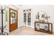 Bright foyer with wood floors, front door, decorative table and mirror, and glass-paneled doors at 3088 Hidden Falls Dr, Buford, GA 30519