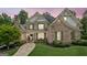 Beautiful brick two-story home with stone accents, manicured lawn, and a welcoming stone walkway at dusk at 3088 Hidden Falls Dr, Buford, GA 30519