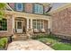 Charming front porch with stone base, white columns, and seating area with stone walkway at 3088 Hidden Falls Dr, Buford, GA 30519