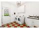 Laundry room featuring a modern washer and dryer, checkered floor, and wash basin at 3088 Hidden Falls Dr, Buford, GA 30519