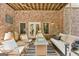 Inviting outdoor living area with brick walls, comfortable seating, a fire table, and a hanging swing at 3088 Hidden Falls Dr, Buford, GA 30519