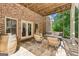 Inviting outdoor living area with brick walls, comfortable seating, a fire table, and a hanging swing at 3088 Hidden Falls Dr, Buford, GA 30519