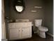 Bathroom featuring a white vanity, toilet, dark walls and decorative mirror at 372 Nalley Dr, Stone Mountain, GA 30087