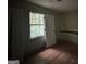 An empty bedroom featuring a window that allows natural light and hardwood floors at 372 Nalley Dr, Stone Mountain, GA 30087
