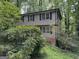 Exterior of a two-story home nestled among lush greenery and foliage at 372 Nalley Dr, Stone Mountain, GA 30087