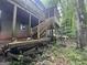 Exterior view of a home featuring a covered deck, wooden staircase, and lush greenery in the backyard at 372 Nalley Dr, Stone Mountain, GA 30087
