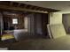 Living room with exposed ceiling and walls, hardwood flooring, and a view into an adjacent room at 372 Nalley Dr, Stone Mountain, GA 30087