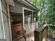 Side of home with the porch and stairs leading to the deck in a wooded area at 372 Nalley Dr, Stone Mountain, GA 30087