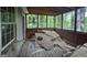 View of the enclosed porch that needs work and is surrounded by trees at 372 Nalley Dr, Stone Mountain, GA 30087