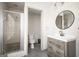 Bathroom features a stand up shower, toilet, and wood cabinet vanity with round mirror at 2689 Spring Rock Ne Ct, Roswell, GA 30075