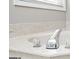 Close-up of soaking tub featuring chrome faucet, marble surround, and window at 2689 Spring Rock Ne Ct, Roswell, GA 30075