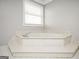 Close-up of bathroom soaking tub with marble surround and chrome faucet at 2689 Spring Rock Ne Ct, Roswell, GA 30075