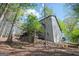 View of the exterior of the home with gray siding surrounded by mature trees at 2689 Spring Rock Ne Ct, Roswell, GA 30075