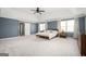 Large main bedroom featuring tray ceiling, neutral carpet, and ensuite bathroom access at 2689 Spring Rock Ne Ct, Roswell, GA 30075