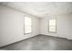 A room with two windows, a white ceiling with recessed lights, and gray flooring at 2689 Spring Rock Ne Ct, Roswell, GA 30075