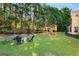 Beautiful backyard featuring mature trees, lush lawn, playset, and cozy firepit area at 2740 Greymont Ct, Cumming, GA 30041