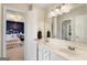 Bright bathroom featuring double sinks and neutral color palette, and open doorway to the bedroom at 2740 Greymont Ct, Cumming, GA 30041