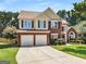 Inviting two-story home features a brick facade, two-car garage, and well-maintained landscaping at 2740 Greymont Ct, Cumming, GA 30041