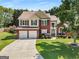 Inviting two-story home featuring a brick facade, manicured landscaping, and a spacious driveway leading to a two-car garage at 2740 Greymont Ct, Cumming, GA 30041