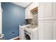 A well-organized laundry room featuring a mosaic backsplash, shelving, and a washer and dryer at 2740 Greymont Ct, Cumming, GA 30041