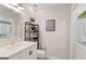 A well lit half-bathroom with a white single sink vanity and open shelving for storage at 4113 Ashford Green Dr, Duluth, GA 30096