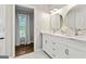 This bathroom boasts a double sink vanity with elegant mirrors and a window providing natural light at 4113 Ashford Green Dr, Duluth, GA 30096