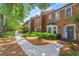 Charming brick townhome featuring mature trees and landscaping, creating a welcoming curb appeal at 4113 Ashford Green Dr, Duluth, GA 30096