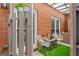 Private patio with brick walls, artificial turf, metal chairs, and a view of the home's exterior at 4113 Ashford Green Dr, Duluth, GA 30096