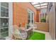 Outdoor patio featuring metal chairs, artificial turf, brick walls, and an enclosed storage chest at 4113 Ashford Green Dr, Duluth, GA 30096