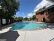 Community pool surrounded by lounge chairs with a brick building to the right at 4113 Ashford Green Dr, Duluth, GA 30096