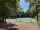 A view of the tennis court in a wooded area at 4113 Ashford Green Dr, Duluth, GA 30096