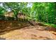 Brick home showcases a screened in porch and lush landscaping on this beautiful wooded lot at 3030 Spalding Dr, Sandy Springs, GA 30350