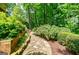Stone path in backyard lined with lush landscaping for tranquil strolls at 3030 Spalding Dr, Sandy Springs, GA 30350